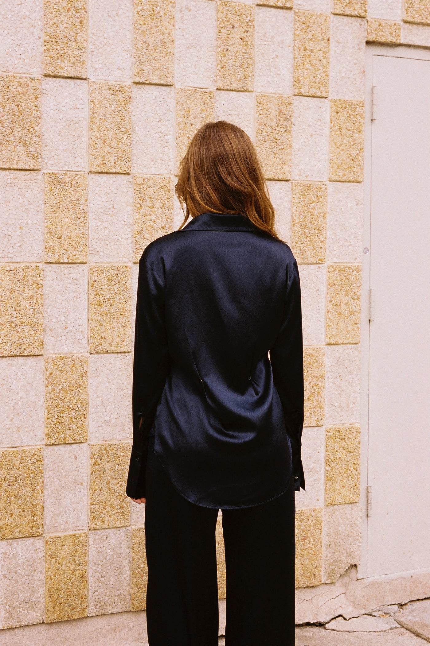 girl standing up wearing roma silk pants and borro silk button up in navy