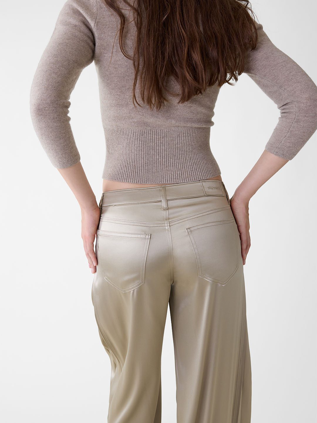Back view of khaki stretch silk wide-leg jeans with five-pocket styling and a mid-rise fit on a model.