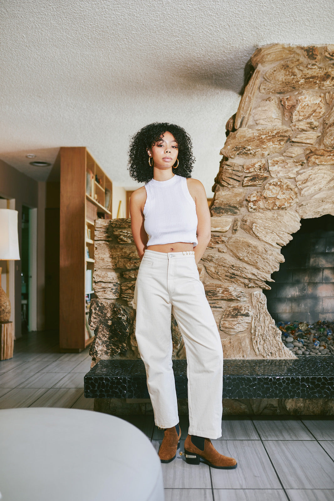 girl standing up wearing mizawe berlin pant in white with gold ring piercings