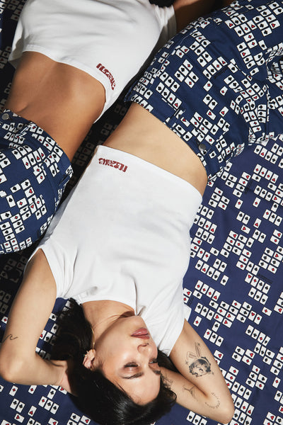 girls laying down wearing reno pant in poker print and white shirt