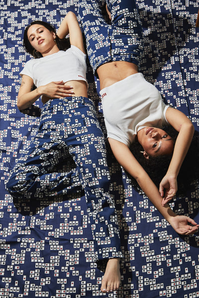 two girls laying down wearing mizawe reno pant in playing cards print and white best baby tee shirt